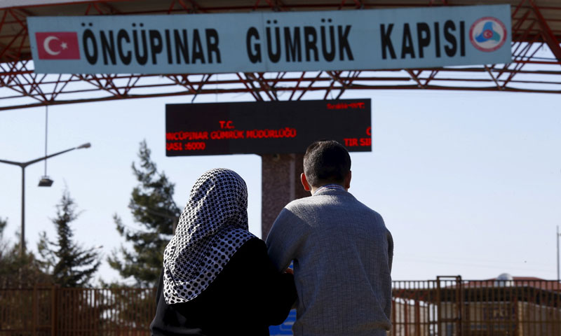 سوريان يقفان على الجانب التركي من معبر أونكوبينار بانتظار والديهما - 5 آذار 2016 (رويترز)
