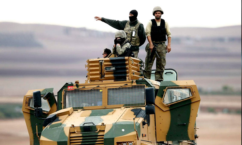 عناصر من الجيش التركي فوق عربة عسكرية على الحدود السورية التركية - (getty image)
