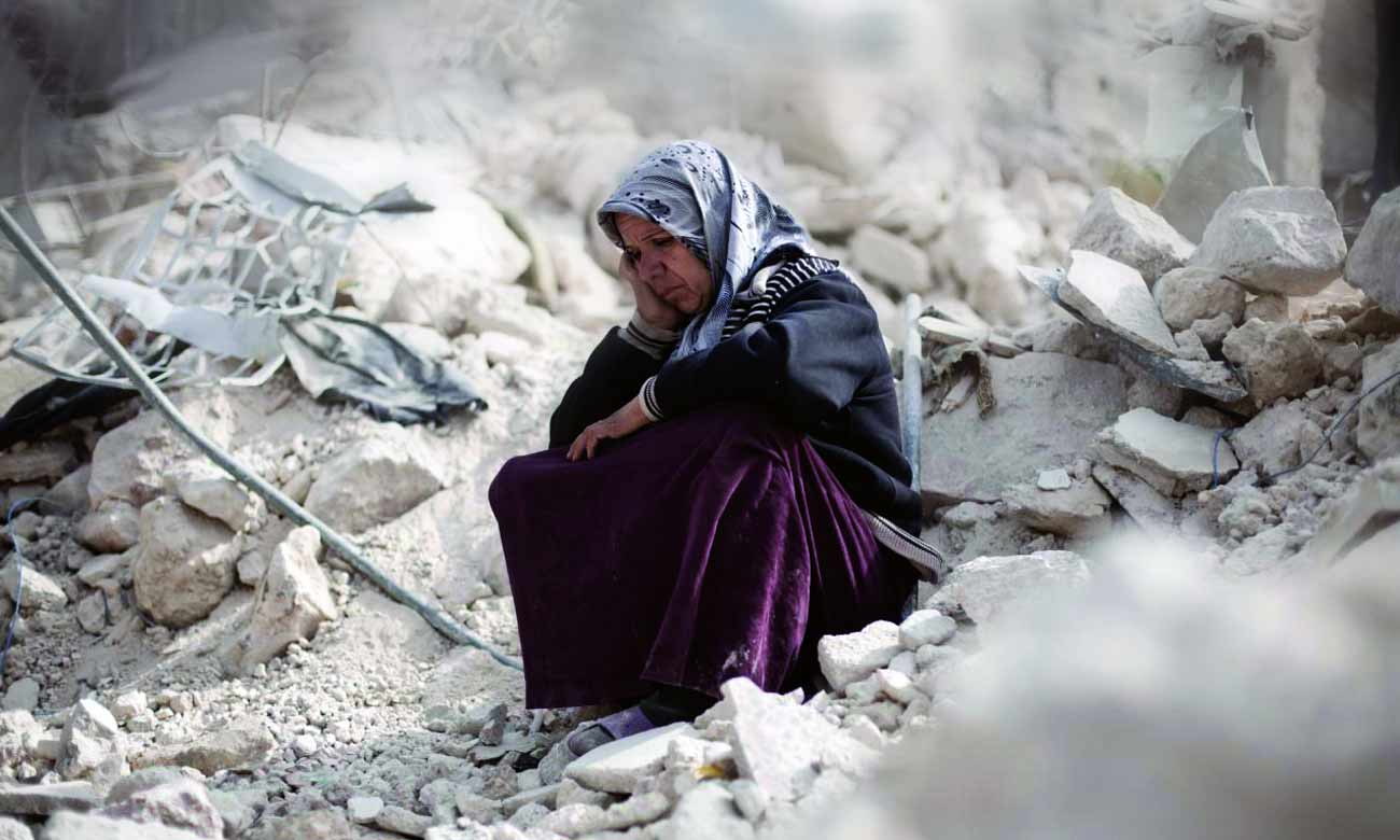 امرأة سورية تجلس بين الركام في حلب - 2013 (AFP)

