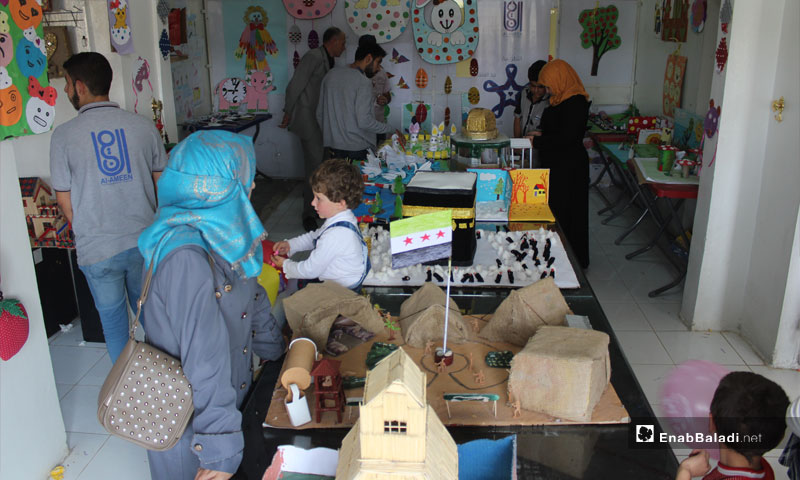 معرضًا للرسوم والأعمال اليدوية المصنعة من نفايات المنازل والمعامل التي أعيد لتدويرها في بلدة حاس جنوبي إدلب تشرين أول 2018 (عنب بلدي)
