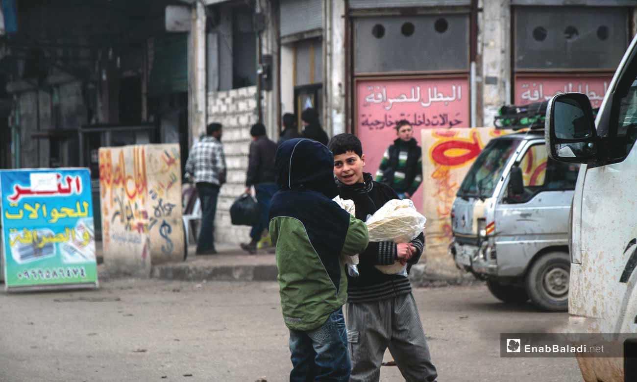 أطفال يحملون الخبز صباحًا في مدينة إدلب – 17 كانون الثاني (عنب بلدي)