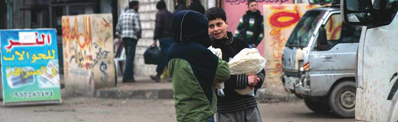 أطفال يحملون الخبز صباحًا في مدينة إدلب – 17 كانون الثاني (عنب بلدي)