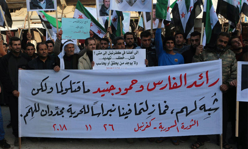 مظاهرة في مدينة كفر نبل احتجاجًا على اغتيال الناشطين رائد الفارس وحمود جنيد، 26 من تشرين الثاني 2018، المصدر: (صفحة لافتات كفر نبل المحتلة في "الفيس بوك")