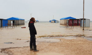 نازح في مخيم العريشة جنوبي الحسكة، ينظر إلى المياه التي غمرت الخيام - 6 كانون الأول 2018 (UNSYRIA)
