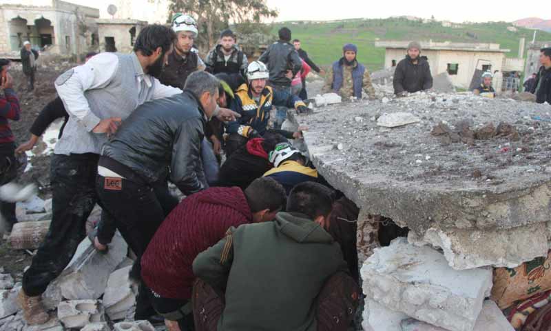 فرق الدفاع المدني ومدنيون يحاولون انتشال الضحايا من تحت أنقاض منزل مدمر بقصف بطائرات روسية في بلدة المنطار غربي إدلب 9 آذار 2019 (الدفاع المدني)
