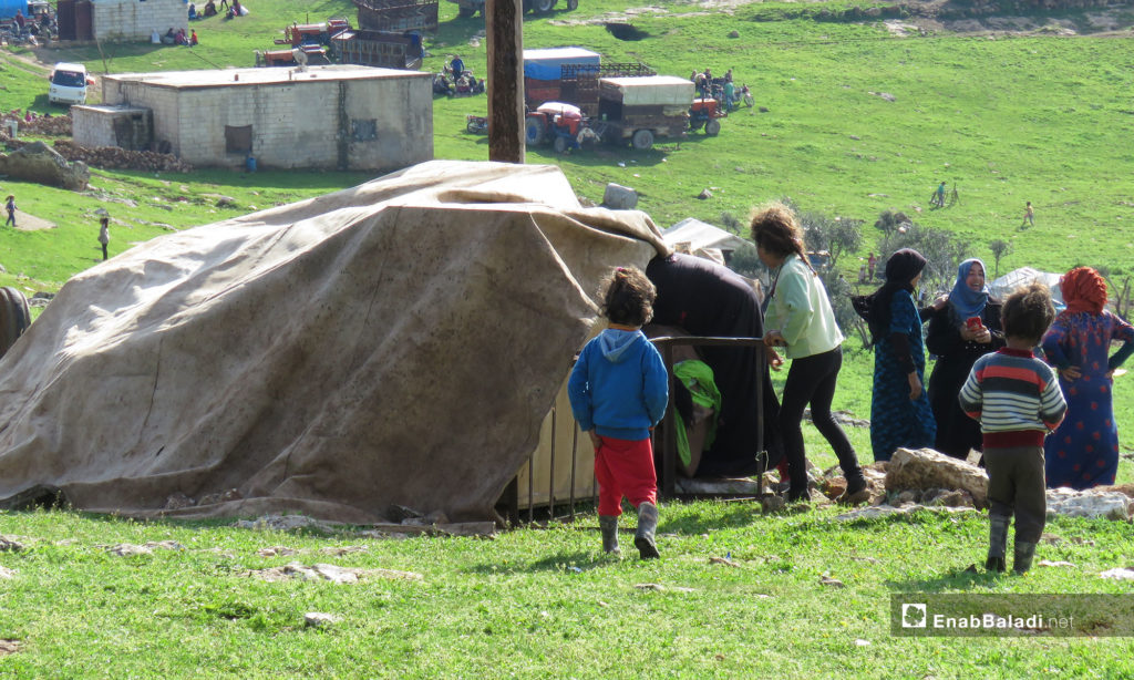 أطفال من قرية الحويز خلال النزوح إلى قرية شير المغاور تحت حماية القاعدة التركية في سهل الغاب - 18 من آذار 2019 (عنب بلدي)