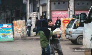 أطفال يحملون الخبز صباحًا في مدينة إدلب – 17 كانون الثاني (عنب بلدي)
