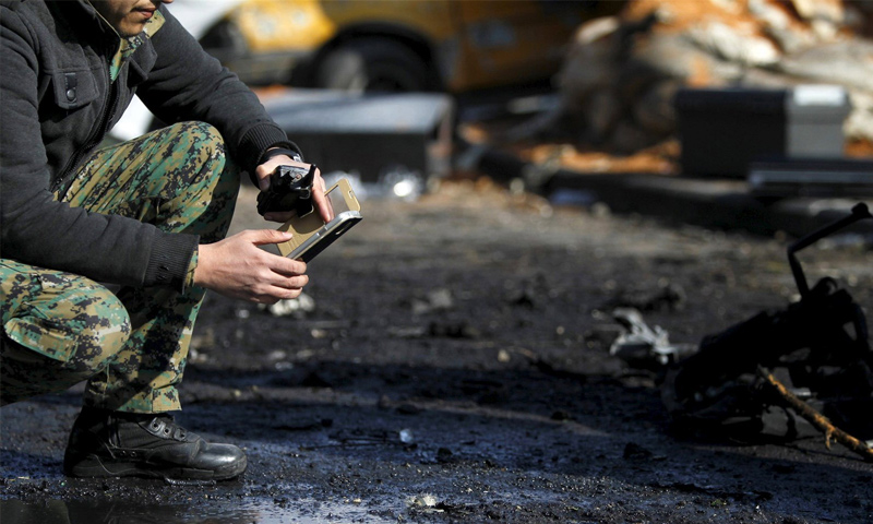 جندي في قوات الأسد يستخدم هاتفه المحمول وهو يتفقد موقع التفجير الانتحاري في نادي ضباط الشرطة في دمشق - 9 شباط 2016 (رويترز)