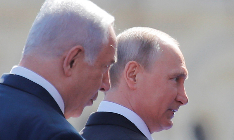 الرئيس الروسي فلاديمير بوتين ورئيس الوزراء الإسرائيلي بنيامين نتنياهو يصلان إلى موكب يوم النصر - نيسان 2018 (رويترز)
