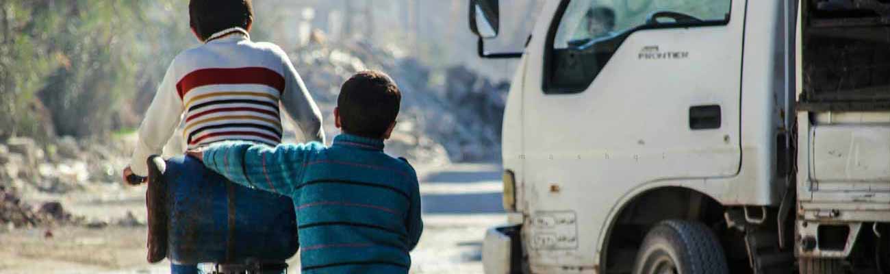 طفلان يحملان أسطوانة غاز على دراجة في الغوطة الشرقية- 2 نيسان 2019 (عدسة شاب دمشقي فيس بوك)