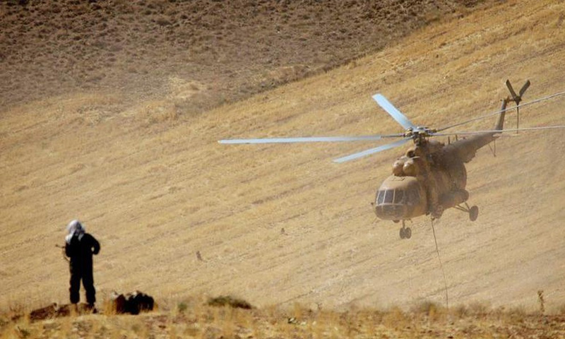قناص إيراني يقف على تل بينما تحلق طائرة هليكوبتر فوق المناورات العسكرية للحرس الثوري في غرب إيران - نيسان 2019 (رويترز)