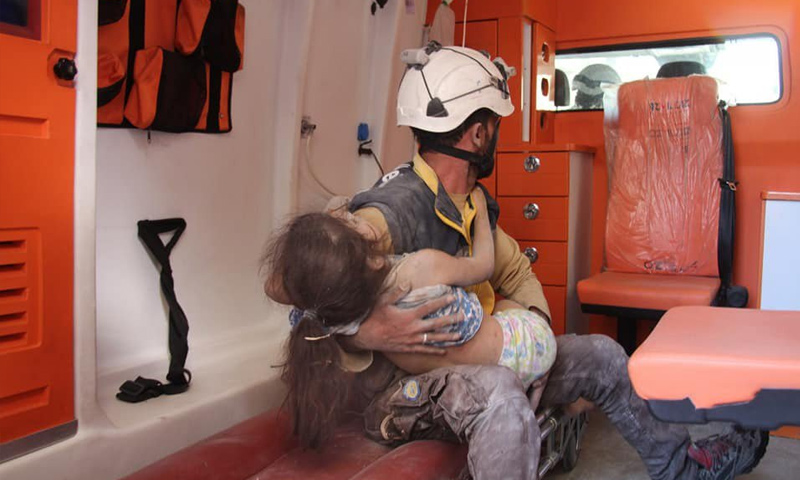 عنصر من الدفاع المدني يسعف طفلة جرحت بقصف طائرات النظام السوري الحربية على ريف إدلب - 29 من أيار 2019 (الدفاع المدني)