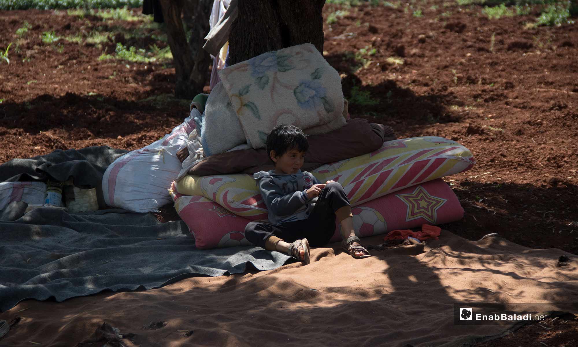 نزوح طفل مع أهله إلى الحدود السورية التركية هربًا من القصف - 3 من آيار 2019 (عنب بلدي)