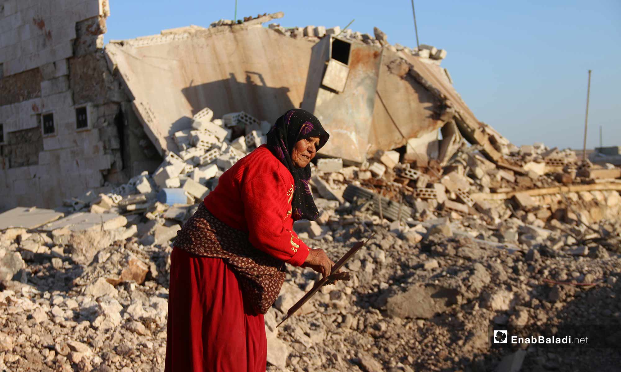 أمراة بين ركام منزلها بعد قصفه بغارة روسية في كفرنبل بريف إدلب - 20 من أيار 2019 (عنب بلدي)
