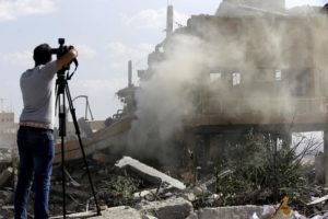 صحفي يصور حطام مبنى مدمر في مجمع مركز الدراسات والبحوث العلمية في منطقة برزة شمال دمشق - 2018( AFP)
