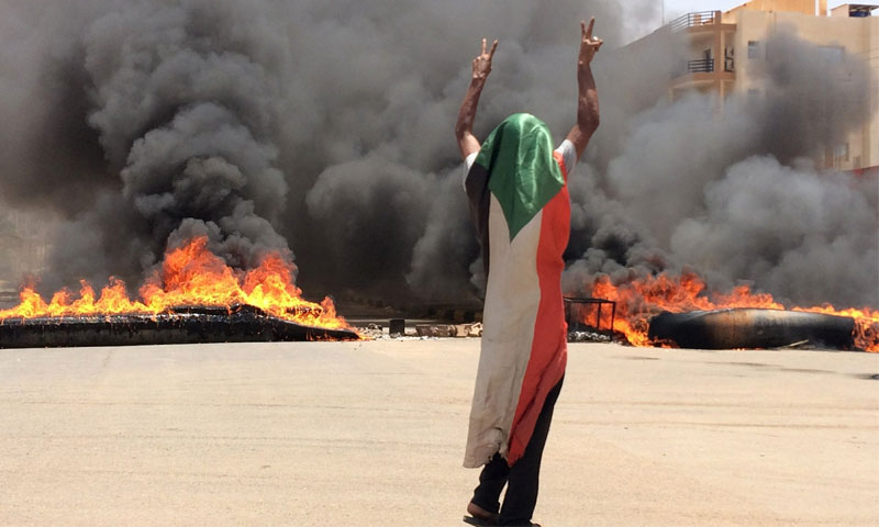 متظاهر يرتدي العلم السوداني في الخرطوم - 3 حزيران 2019 (AP)