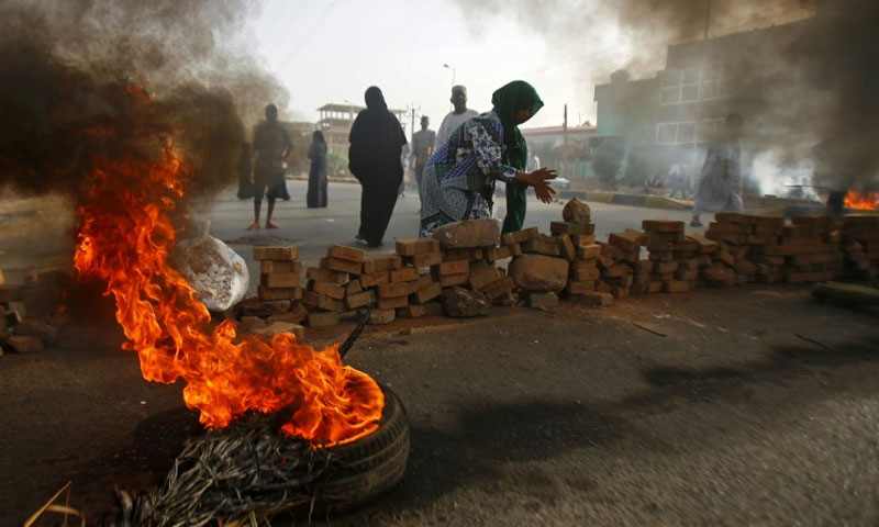 المتظاهرين في السودان أثناء قطعهم أحد الطرق بالإطارات المشتعلة في الخرطوم - 3 حزيران 2019 (AFP)