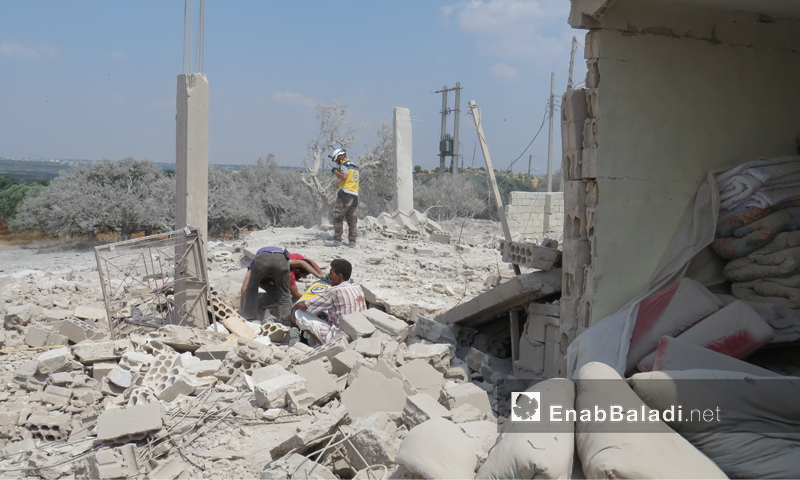 عناصر من الدفاع المدني يخلون ضحايا جراء القصف الذي استهدف بلدة الفطيرة جنوبي إدلب- 15 من حزيران 2019 (عنب بلدي)