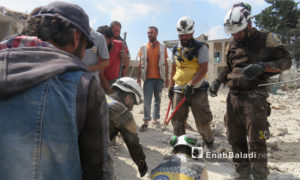 عناصر من الدفاع المدني يخلون ضحايا جراء القصف الذي استهدف بلدة الفطيرة جنوبي إدلب- 15 من حزيران 2019 (عنب بلدي)