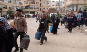 مواطنون في محافظة درعا يشترون جرات الغاز من نقاط التوزيع المتنقلة - 17 من كانون الأول 2018 (سانا)

