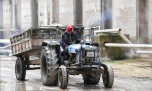 موظف يقود جرارًا في مصنع للأسمدة خارج مدينة حمص- 13 من كانون الثاني 2019 (AP)

