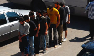 سجناء سوريون أمام مقر لشرطة النظام في دمشق – أيلول 2012 (AFP)
