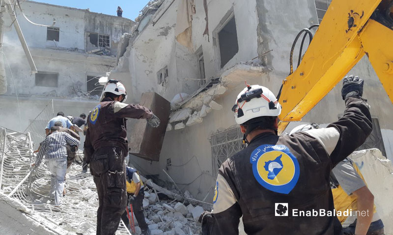 فرق الدفاع المدني تعمل على انتشال الضحايا والجرحى في الأحياء السكنية التي طالتها غارات روسية في مدينة أريحا جنوبي إدلب 27 تموز 2019 (عنب بلدي)