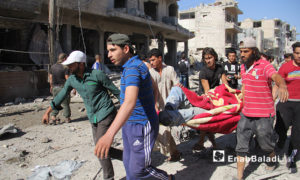 عناصر الدفاع المدني أثناء انتشال  مدنيين عالقين تحت أنقاض المنازل بعد تعرضها لغارات روسية في معرة النعمان جنوب إدلب 22 تموز 2019(عنب بلدي)