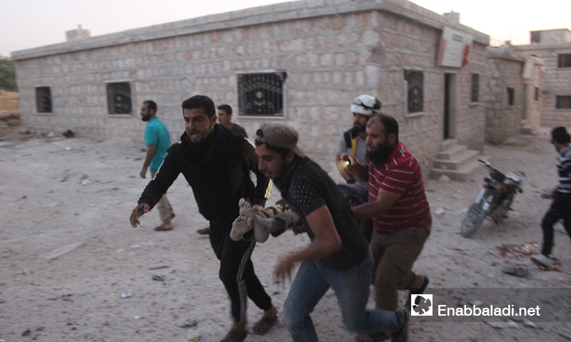 انتشال مدنيين من تحت أنقاض المنازل في تجمع للنازحين بعد تعرضهم لغارات روسية في بلدة حاس بريف إدلب الجنوبي 16 آب 2019 (عنب بلدي)
