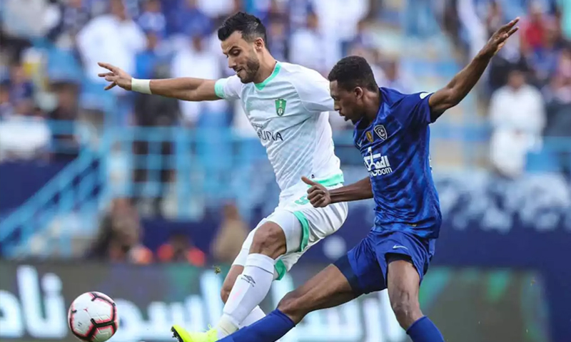 اللاعب عمر السومة مع مدافع نادي الهلال السعودي في لقاء "الكلاسيكو" (الرياضة السعودية)