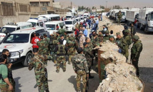 قوات روسية بمرافقة قوات النظام السوري بمدخل معبر مخيم الوافدين في دوما (سبوتنيك)

