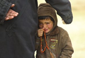 طفل سوري يقف إلى جوار والده في انتظار الحصول على مساعدة إنسانية في إدلب - 13 كانون الثاني 2013 (رويترز)
