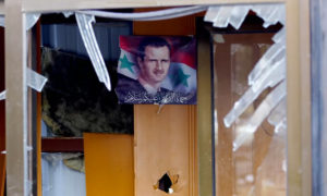 صورة لرئيس النظام السوري بشار الأسد في بناء متضرر في دمشق - 9 شباط 2016 (AFP)