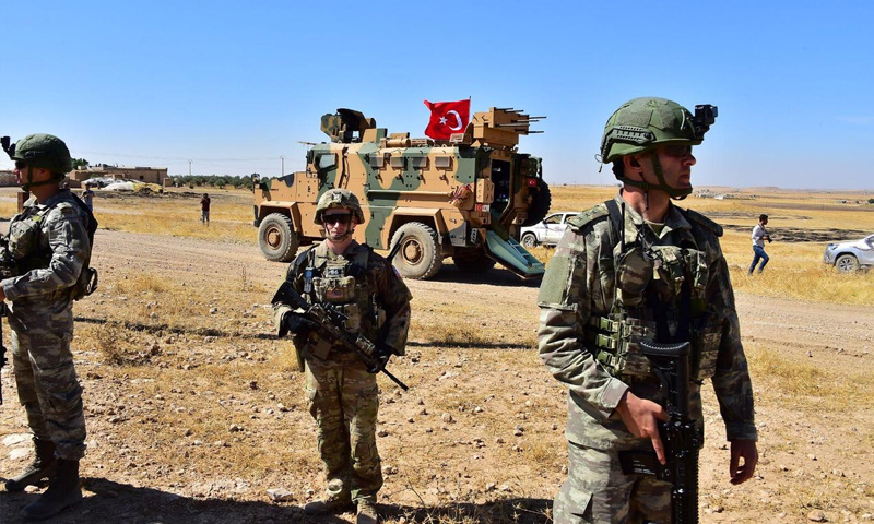 جنود أتراك وأمريكيون على الحدود السورية التركية في أثناء تسيير دورية برية شمالي سوريا (رويترز)