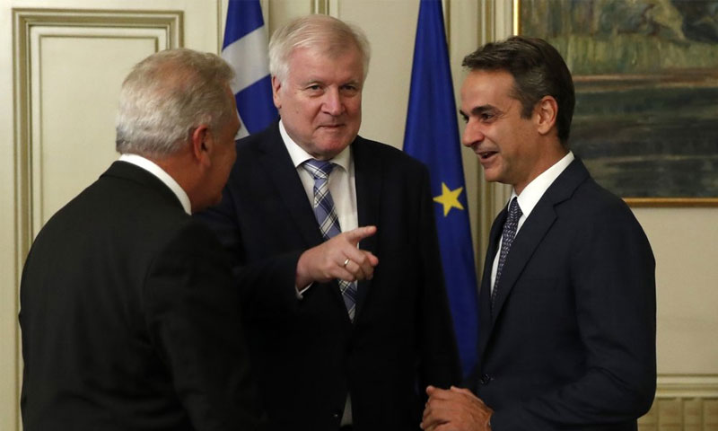 رئيس الوزراء اليوناني كيرياكوس ميتسوتاكس مع وزير الداخلية الألماني هورست زيهوفر ومفوض الاتحاد الأوروبي ماكسموس مانسون في اجتماع في أثينا - 4 تشرين الأول 2019 (AP)