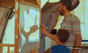 استاذ يعلم الأطفال في خيمة بريف إدلب 2019 (عنب بلدي)
