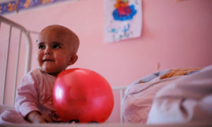 طفل يلعب بالون داخل جناح السرطان في مستشفى الأطفال بسوريا -  20 شباط 2017 (رويترز)