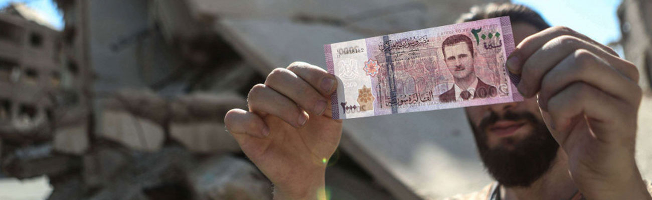 مواطن سوري يحمل فئة نقدية من 2000 ليرة سورية (shutterstock)
