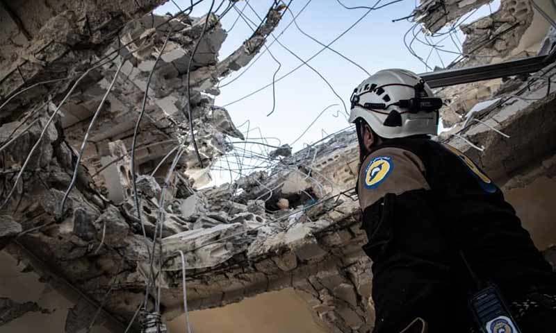 عنصر من الدفاع المدني ينظر إلى السماء من فتحة سقف منزل مهدم - 30 من كانون الأول 2019 (الدفاع المدني في حلب)