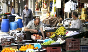 بائع ينسق معروضاته من الفاكهة في سوق شعبي بدمشق - 21 حزيران 2019 (AFP)