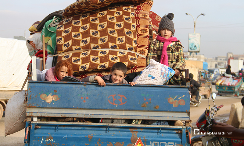 أطفال سوريون يعتلون متااع منازلهم خلال نزوحهم من جبل الزاوية جنوبي إدلب نتيجة قصف قوات النظام وروسيا - 27 كانون الثاني 2020 (عنب بلدي)