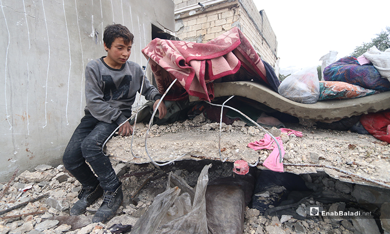 طفل يجمع ما تبقى من أثاث منزله بعد قصفه في بلدة كفر تعال بريف حلب الغربي - 20 من كانون الثاني 2020 (عنب بلدي)
