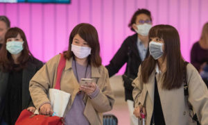 مواطنون صينيون يرتدون الكمامات الطبية للوقاية من فيروس كورونا (CNN)