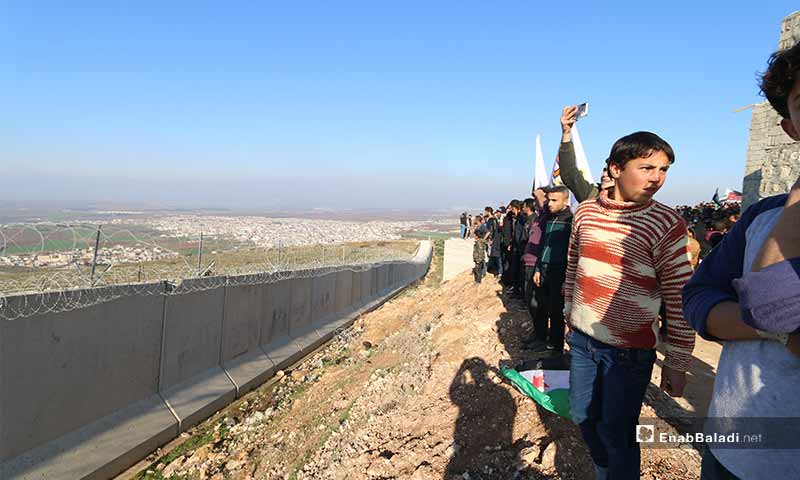 متظاهرون سوريون أمام الحائط الإسمنتي الفاصل بين سوريا وتركيا - 2 شباط 2020 (عنب بلدي)