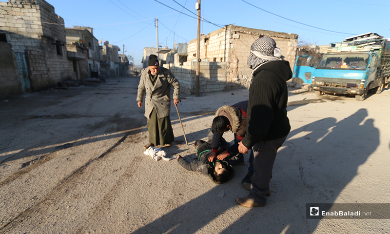 مدنيون يحاولون انتشال أحد ضحايا البراميل المتفجرة على بلدة كفرنوران غربي حلب- 9 من شباط 2020 (عنب بلدي)