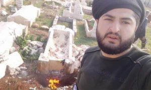 عنصر للنظام قام بحرق ونبش قبر في بلدة حيان- 17 من شباط (مصطفى كسحو/فيس بوك)