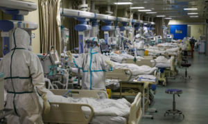 أطباء وممرضون في ملابس وقائية يعالجون مرضى فيروس كورونا الجديد في مستشفى في ووهان بالصين- 6 من شباط (رويترز)