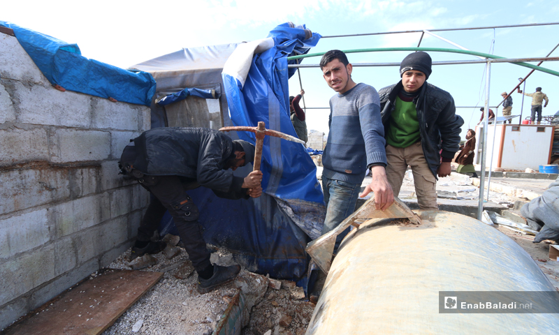 نازحون يحاولون إصلاح خيامهم بعد تضررها بعاصفة هوائية في جسر الشغور غربي إدلب- 6 آذار 2023(عنب بلدي/ محمد نعسان دبل)