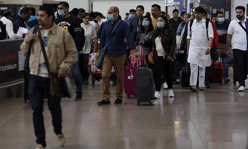 مسافرون يرتدون أقنعة واقية لدى وصولهم لمطار دبي الدولي يوم 29 من كانون الثاني 2020- (رويترز)