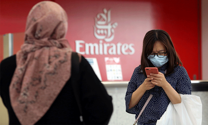 امرأة تضع كمامة في مطار دبي الدولي يوم 29 من كانون الثاني 2020 - (رويترز)